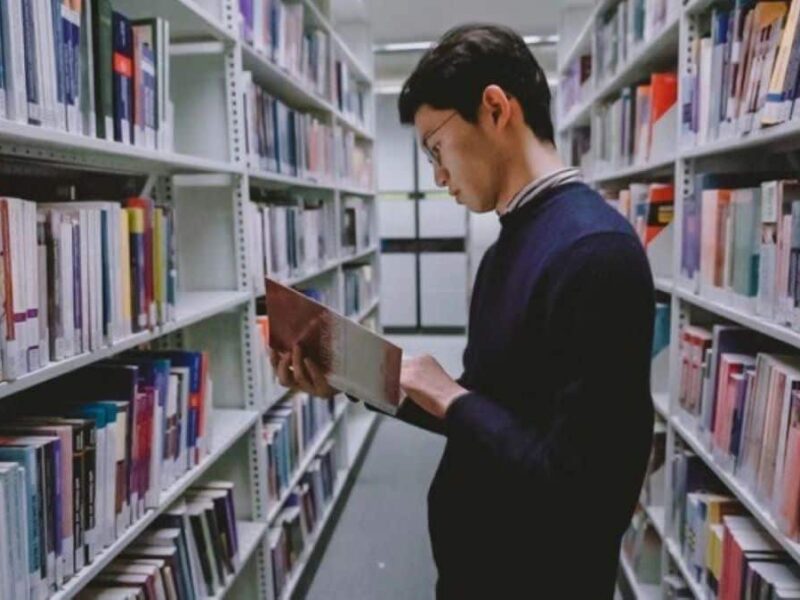 Student in the library looking at books